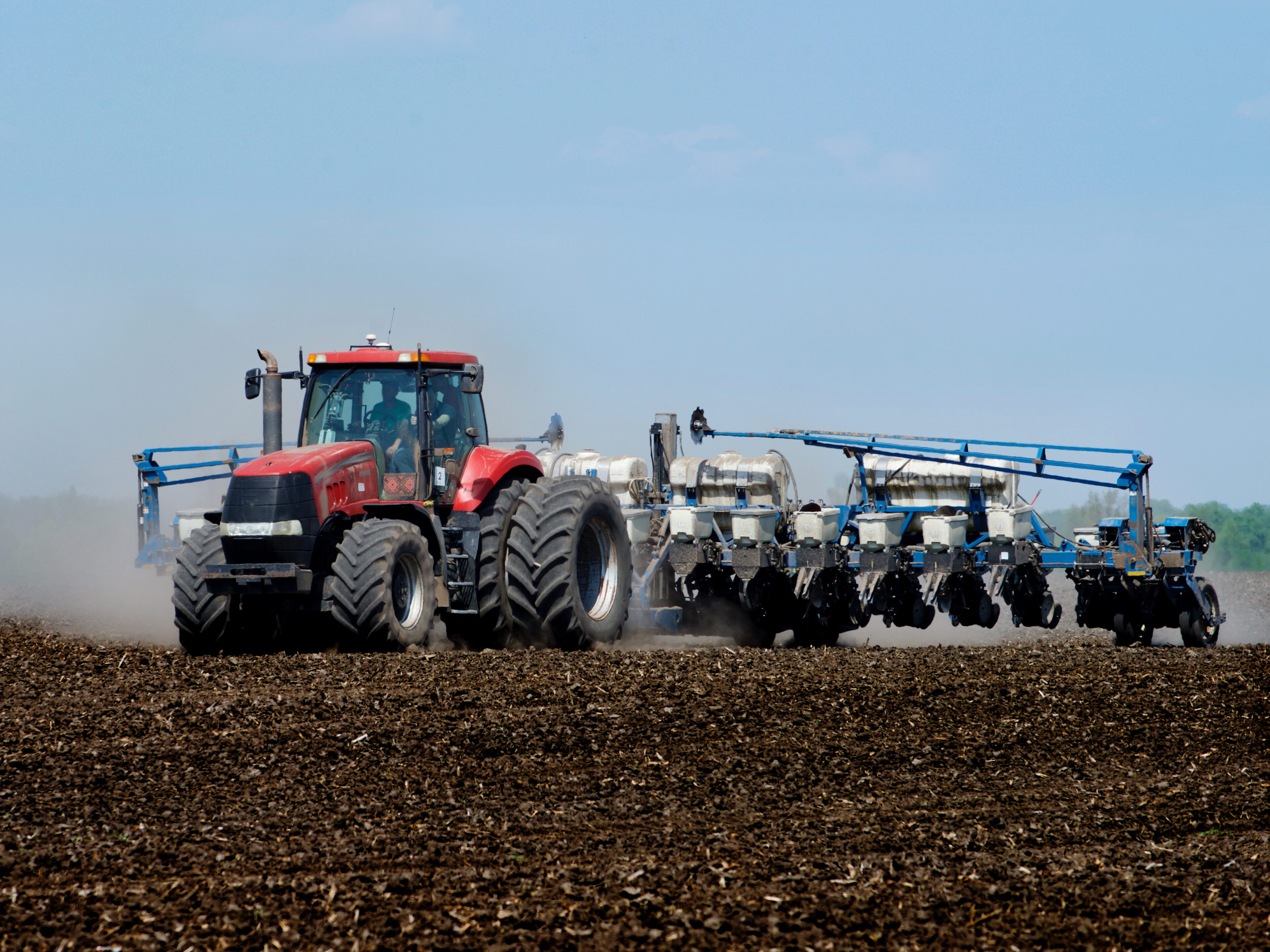 Tractor sowing the corn on the field Texas Refinery Corp